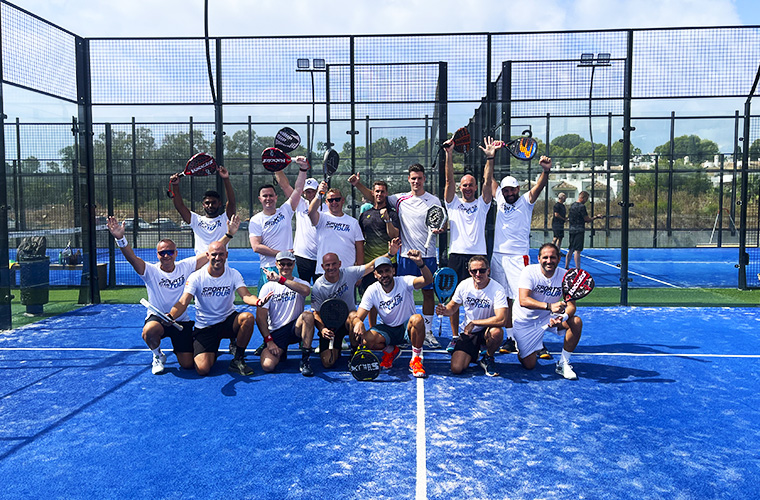 Eine Gruppe Padel-Spieler macht ein Foto mit erhobenen Händen und feiert das Ende des Weekend Padel Camp Marbella.