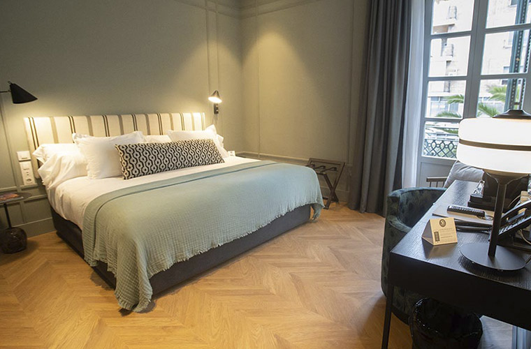 Habitación de hotel amplia y elegante con cama king-size y vistas a la ciudad para los participantes del Weekend Padel Camp Málaga