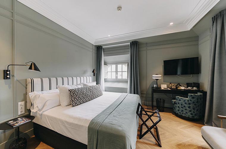 Habitación de hotel moderna con cama king-size, espacio de trabajo y luz natural para los huéspedes del Weekend Padel Camp Málaga