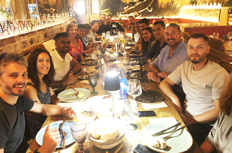 Cena de grupo del Weekend Padel Camp Málaga; participantes del Tour del Club Deportivo compartiendo una comida en un acogedor restaurante.