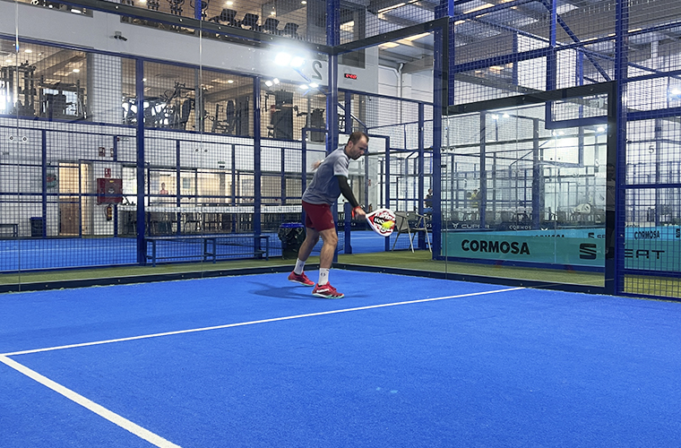 Jugador de pádel practicando revés solo en pista azul durante el Weekend Padel Camp Málaga del Sports Club Tour