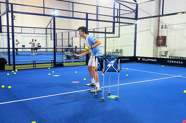 El entrenador de pádel Manu Fernández imparte clases en el Weekend Padel Camp Málaga; los jugadores entrenan en pista azul.