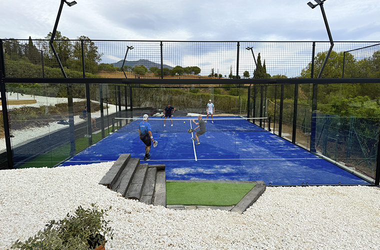 Villa con pista de pádel en Málaga, cuatro personas jugando al pádel en la pista de pádel panorámica junto a la naturaleza.