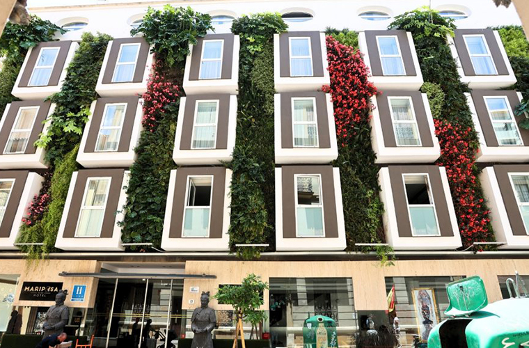 Front facade of Mariposa Hotel Malaga with striking vertical garden and modern windows in downtown Malaga