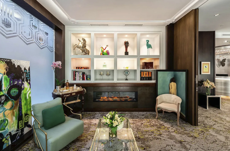Art-filled lounge area at Mariposa Hotel Malaga with fireplace, designer armchairs, and decorative shelves
