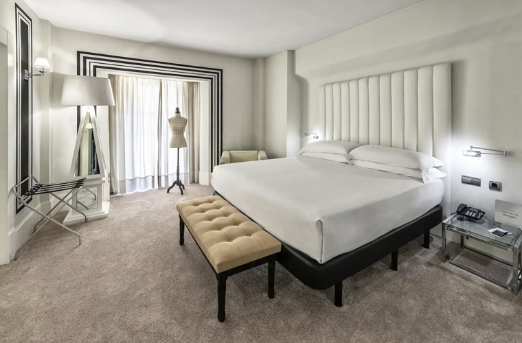 Stylish white double room at Mariposa Hotel Malaga with king-size bed, bench, and designer details