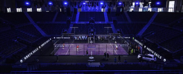 HexagonCup Madrid en una pista cubierta central con iluminación azul y gradas vacías. Los jugadores realizan un partido de entrenamiento en el estadio vacío.